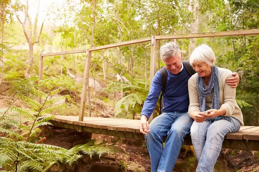 senior couple sitting on a wooden bridge Willow Chiropractic