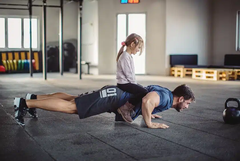 Dad exercising with daughter on his back Willow Chiropractic